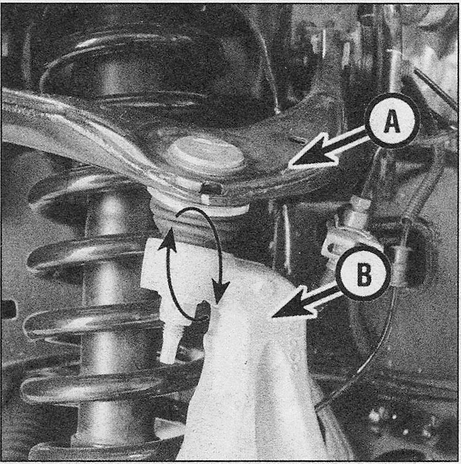 Ford F150 Suspension and steering systems_Balljoints - check and replacement _ Grab the upper control arm (A) and attempt to move it up and down while checking for any movement between the control arm and the steering knuckle (B)