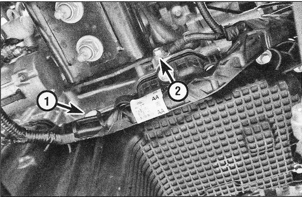 Remove the wiring harness plastic push-pin (1) and ground wire bolt (2)