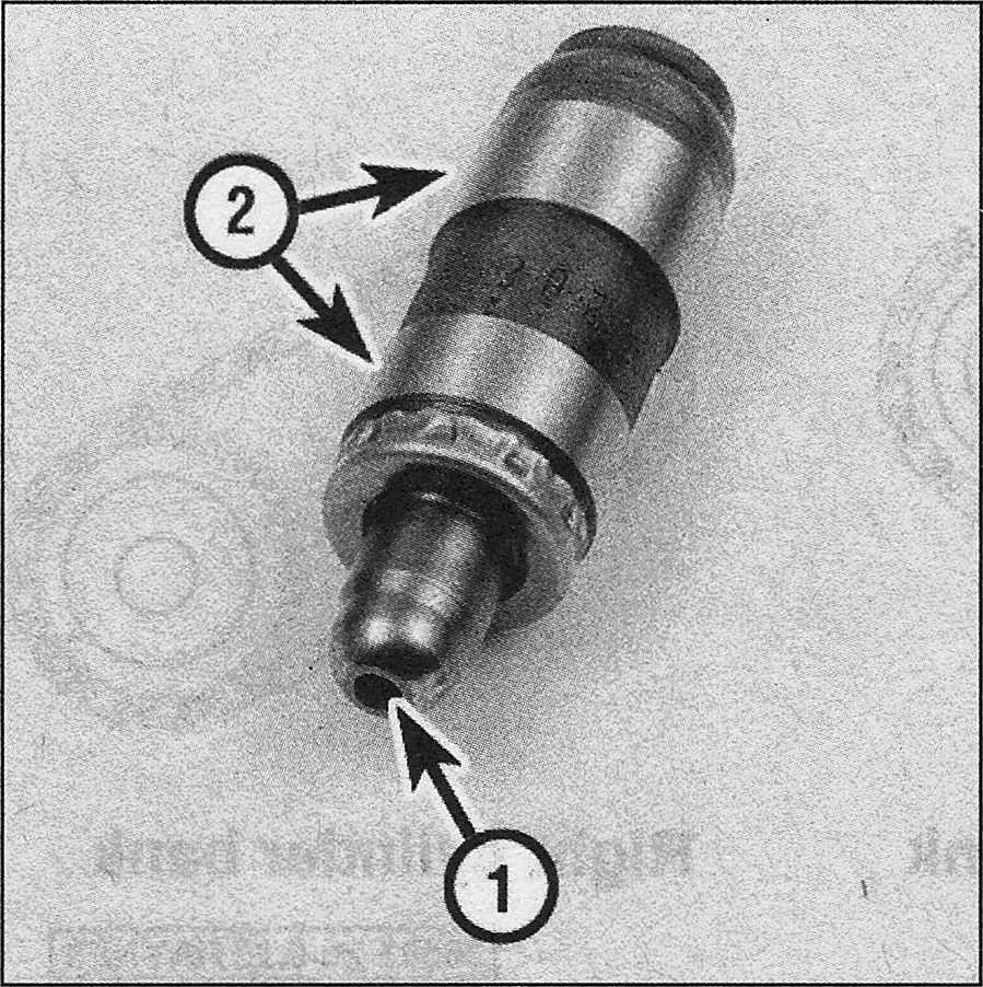 Ford F150 V8 engine_Roller followers and valve lash adjusters - removal, inspection and installation _Inspect the lash adjuster for signs of excessive wear or damage, such as pitting, scoring or signs of overheating (bluing or discoloration), where the tip contacts the camshaft follower (1) and the side surfaces that contact the lifter bore in the cylinder head (2)